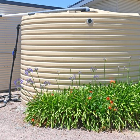 Plastic,Water,Storage,Tank,On,The,Side,Of,A,House Water storage tank as part of a home's eco plumbing system.